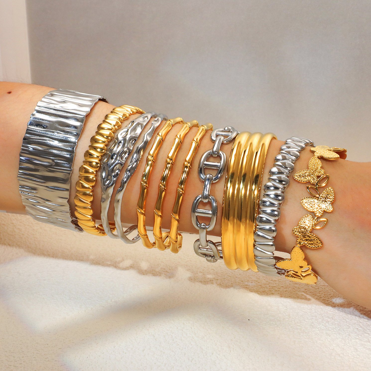 Gold and steel-tone hydraulic-pressed stainless steel bangles in varied textured designs