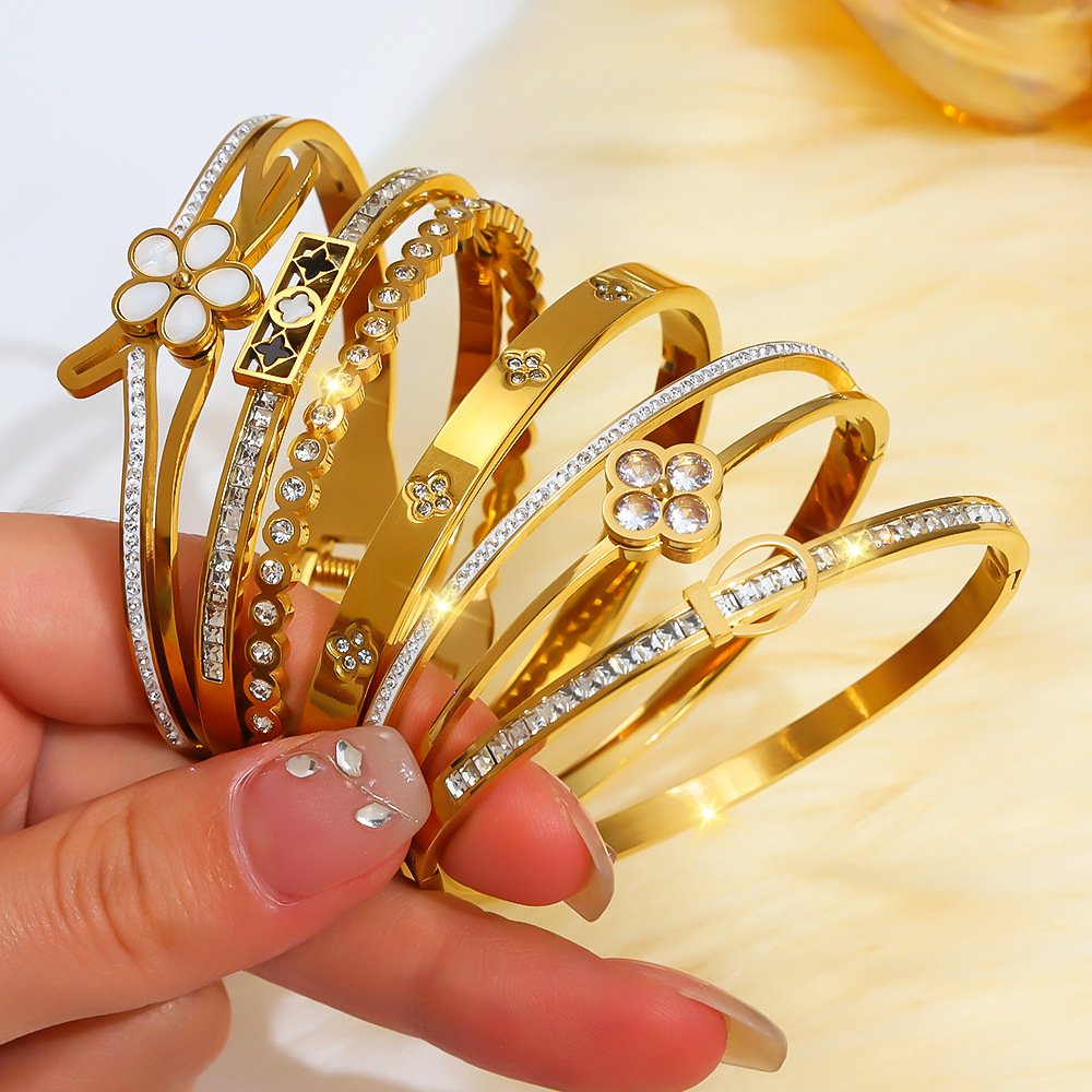 Gold laser-cut and formed stainless steel bangles with engraving, zircon stones and decorative components